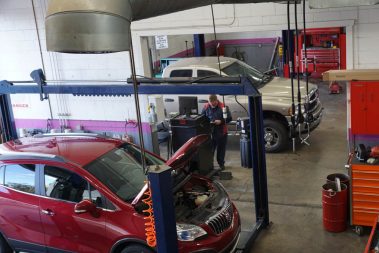 A mechanic at The Muffler Shop inputting data into a computer