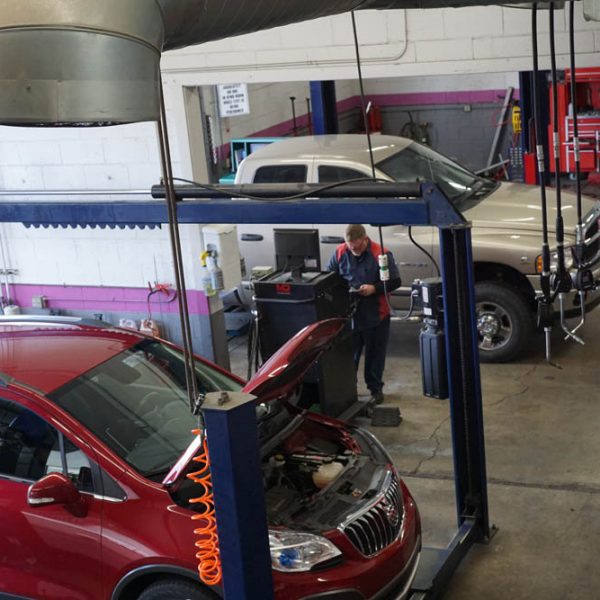 A mechanic at The Muffler Shop inputting data into a computer