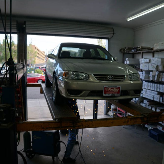 A car being fixed at the Muffler Shop