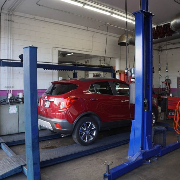 A red car getting fixed at The Muffler Shop